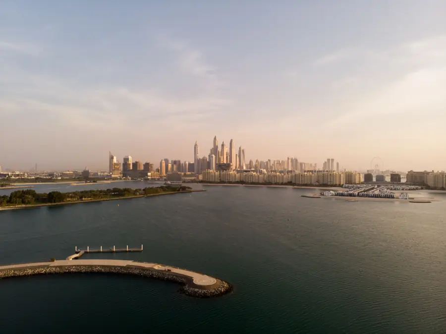 The Dubai skyline at dawn seen across open water